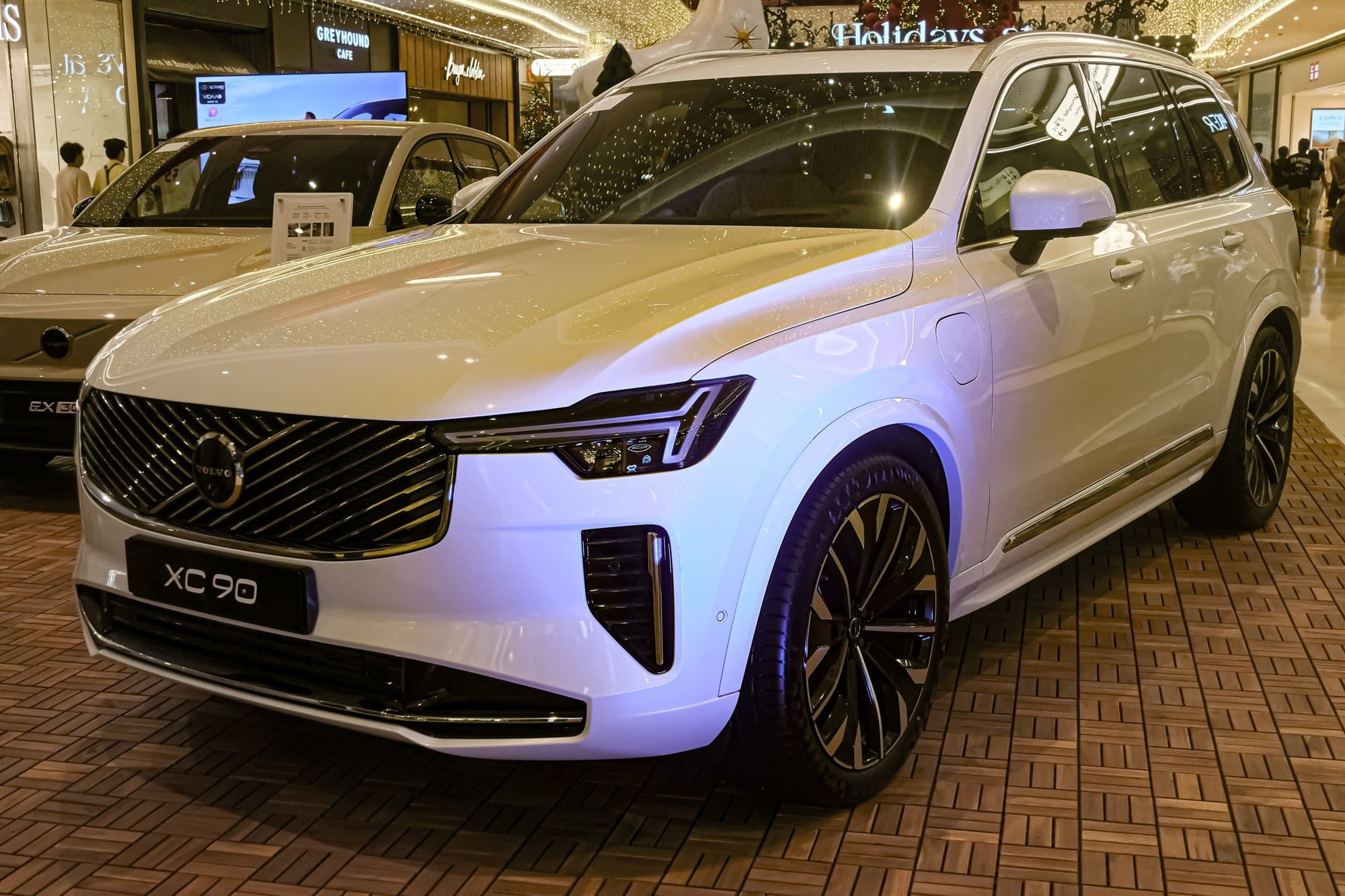 Volvo XC90 T8 (2025 facelift) in Crystal White on a showroom floor